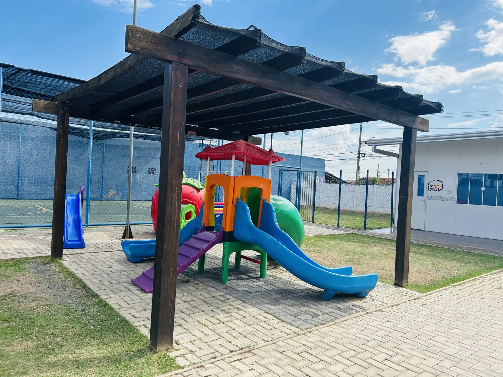 Brinquedo com escorregador sob cobertura no parque da Escola Moranguinho
