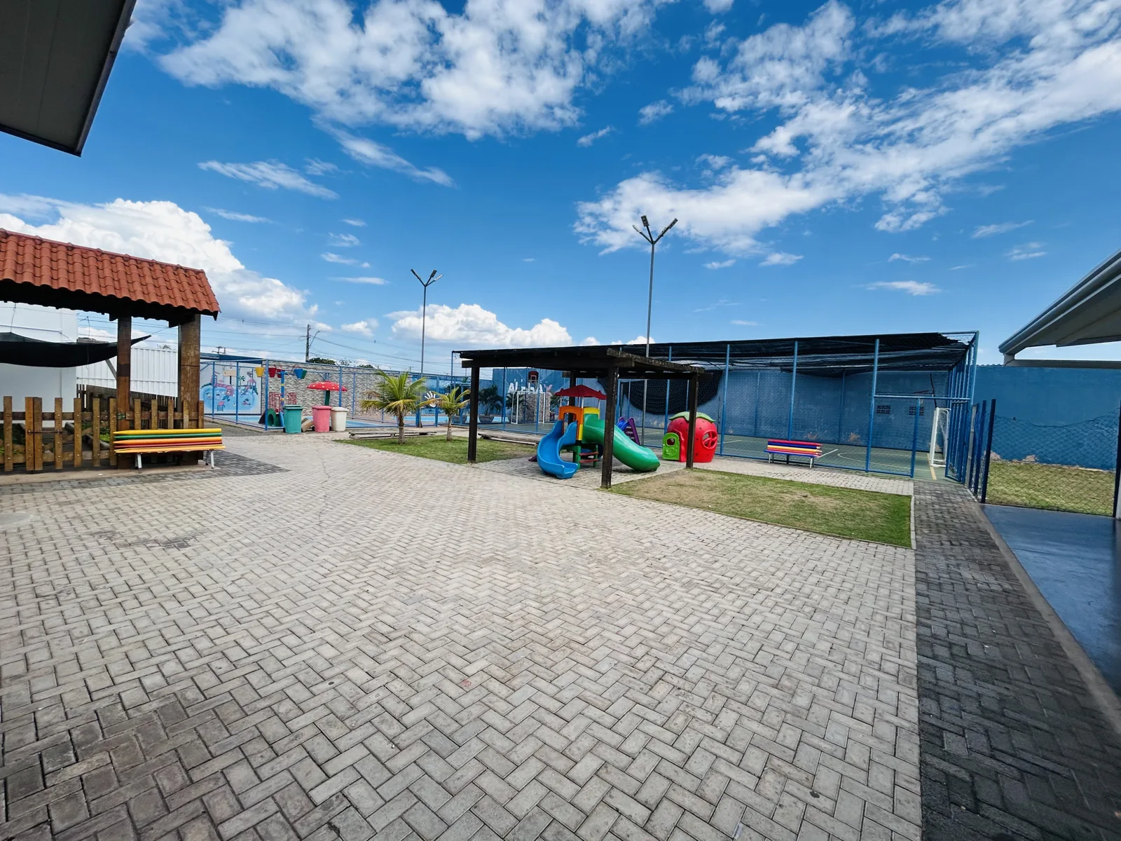 Área externa da escola com pátio e parque infantil