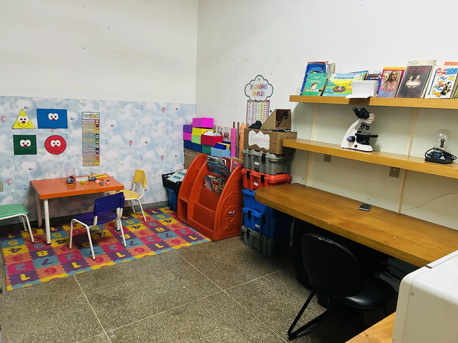 Espaço com livros, mesa de atividades e bancada na escola
