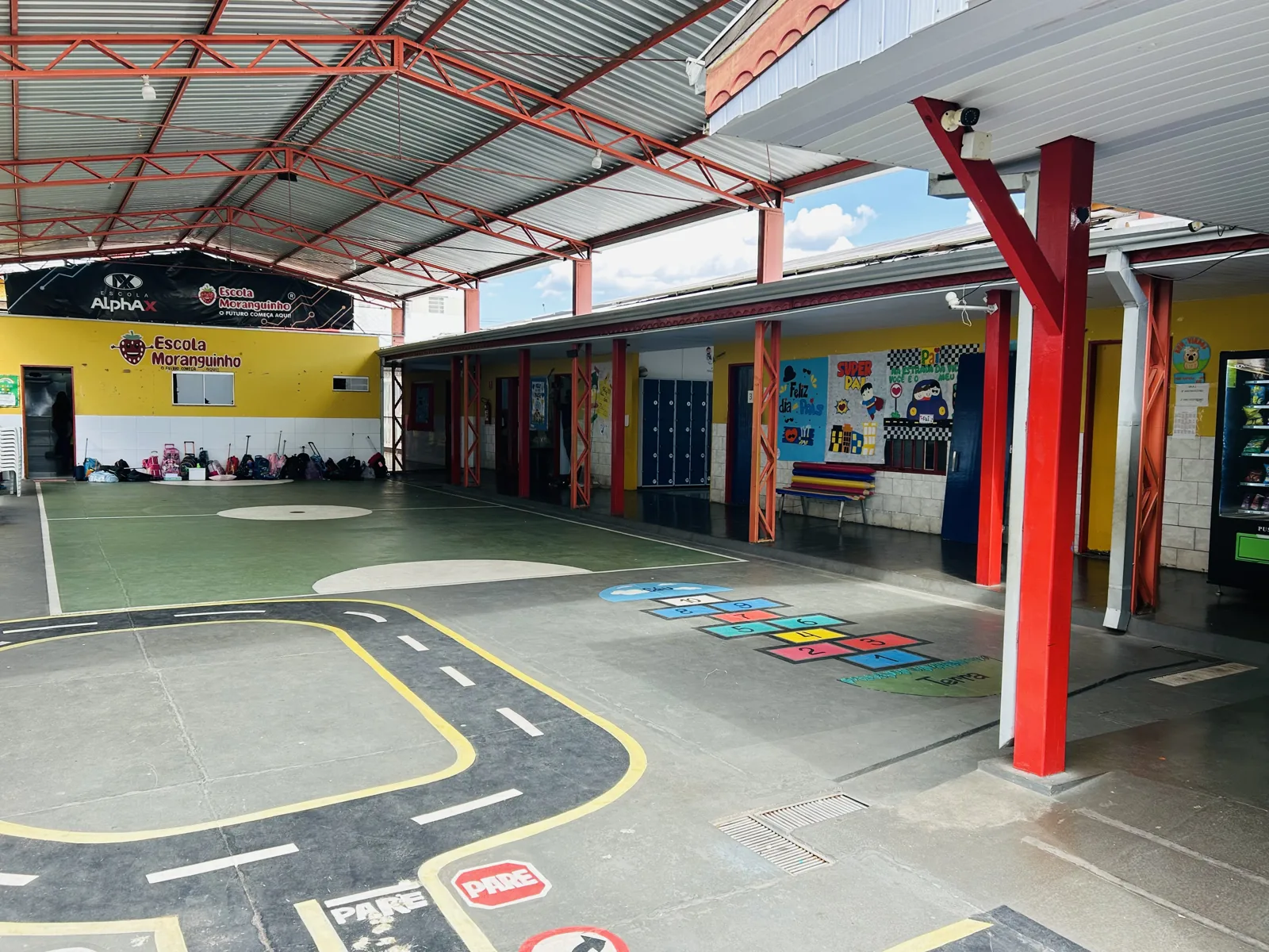 Pátio coberto com desenhos no piso na Escola Moranguinho