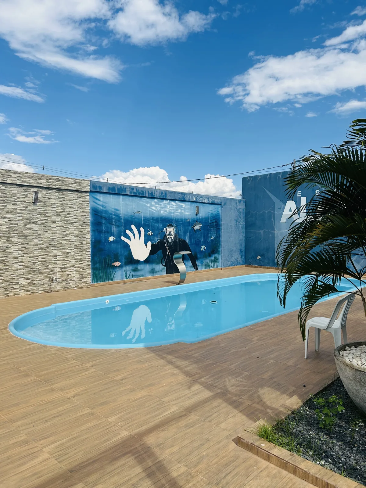 Piscina em área externa com muro pintado na escola